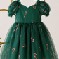 Girls Christmas outfit featuring coordinating green candy cane dresses in baby and girls sizes with puff sleeves and layered tulle.