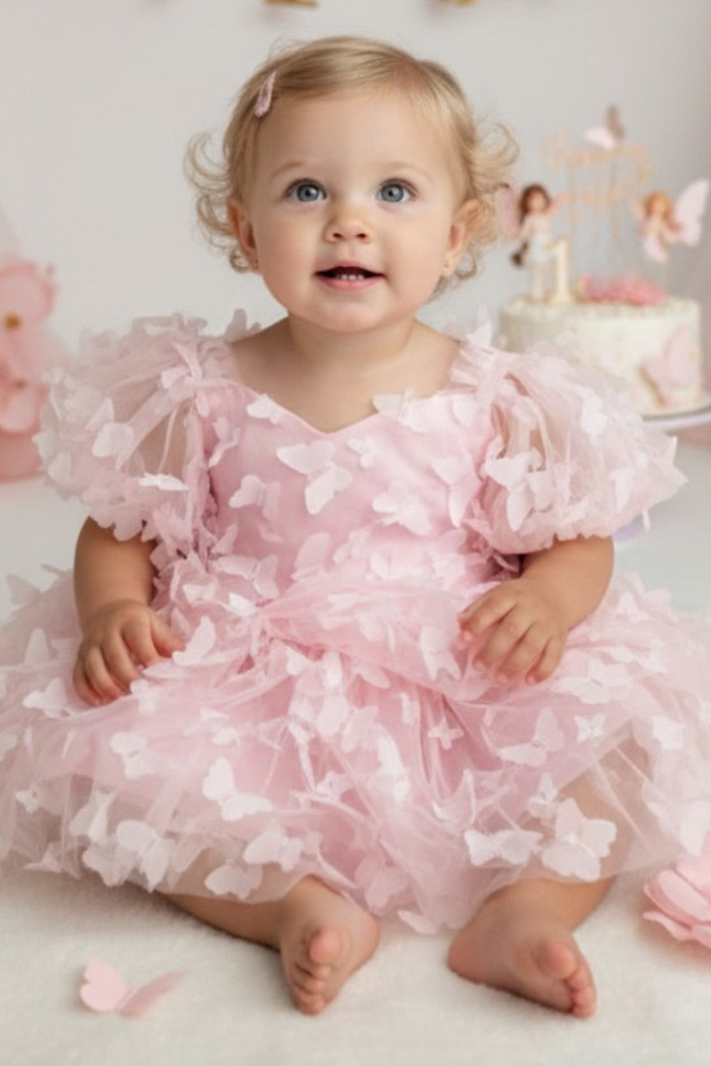 Baby girl in a light pink butterfly first birthday dress for a One Year Fluttered By party